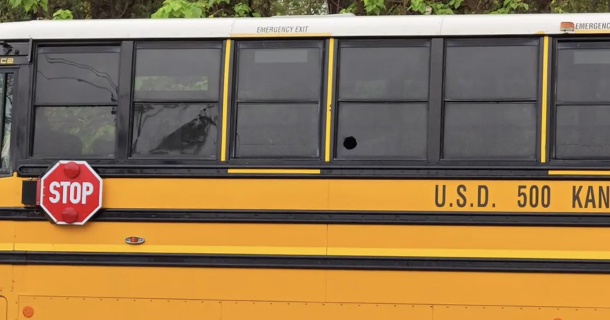 Police investigate near a school bus window struck by gunfire in Kansas City, Kansas
