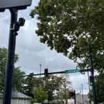 A license plate reader camera mounted on a pole overlooking a city street