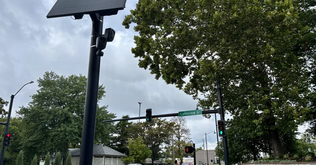 A license plate reader camera mounted on a pole overlooking a city street
